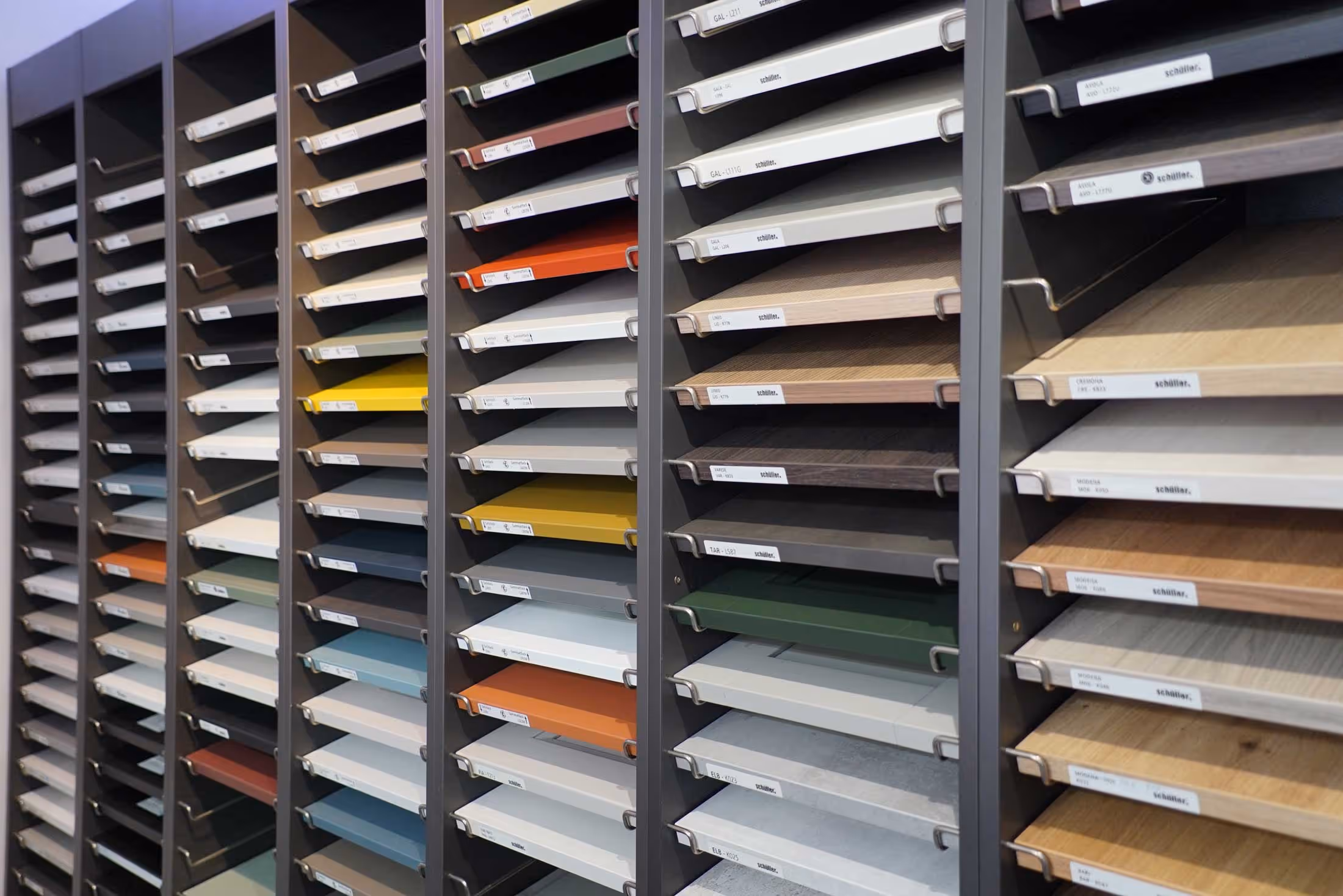 Rows of shelves displaying various laminated board samples in different colors and textures.