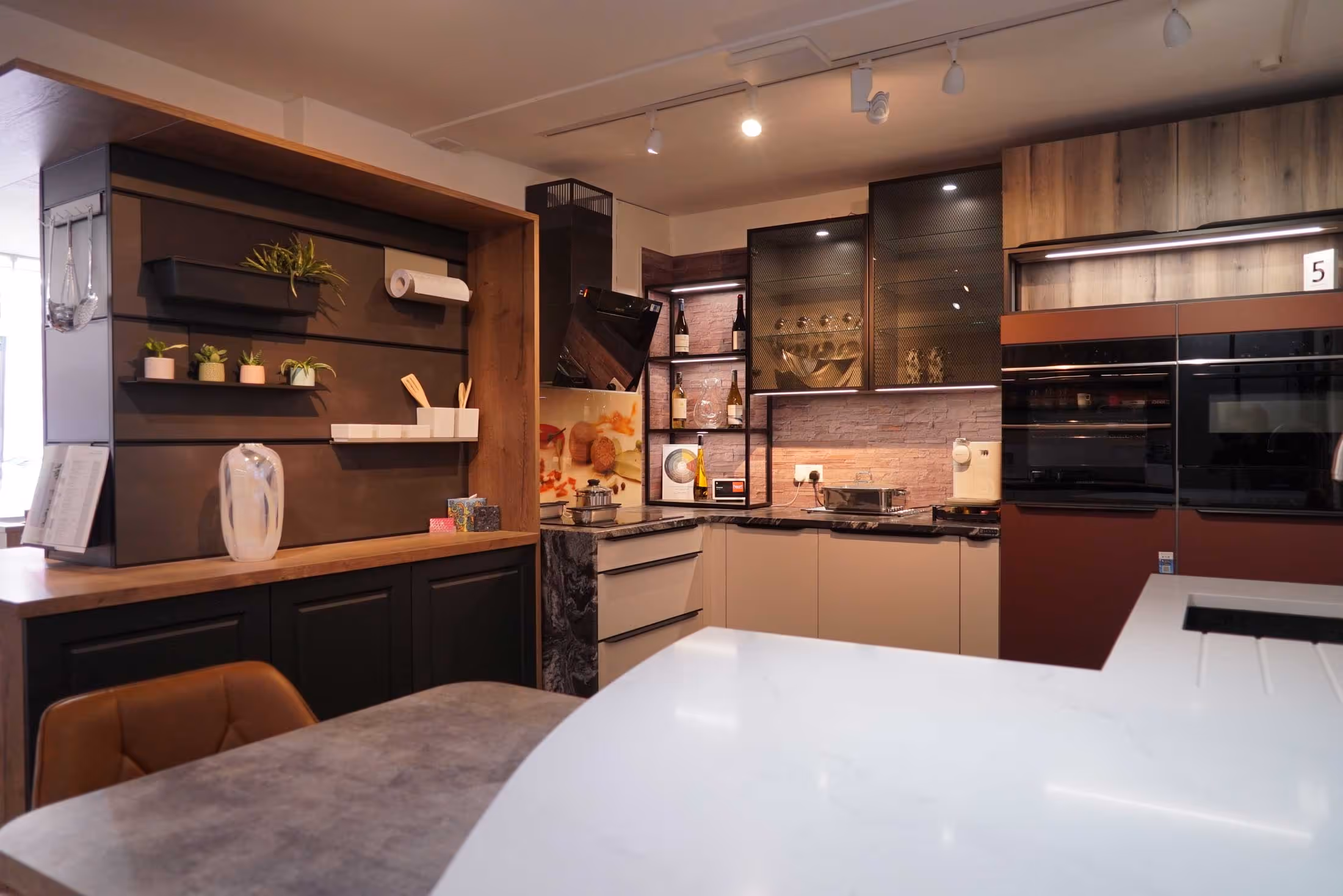 A modern kitchen with sleek appliances, open shelves, and a marble countertop.
