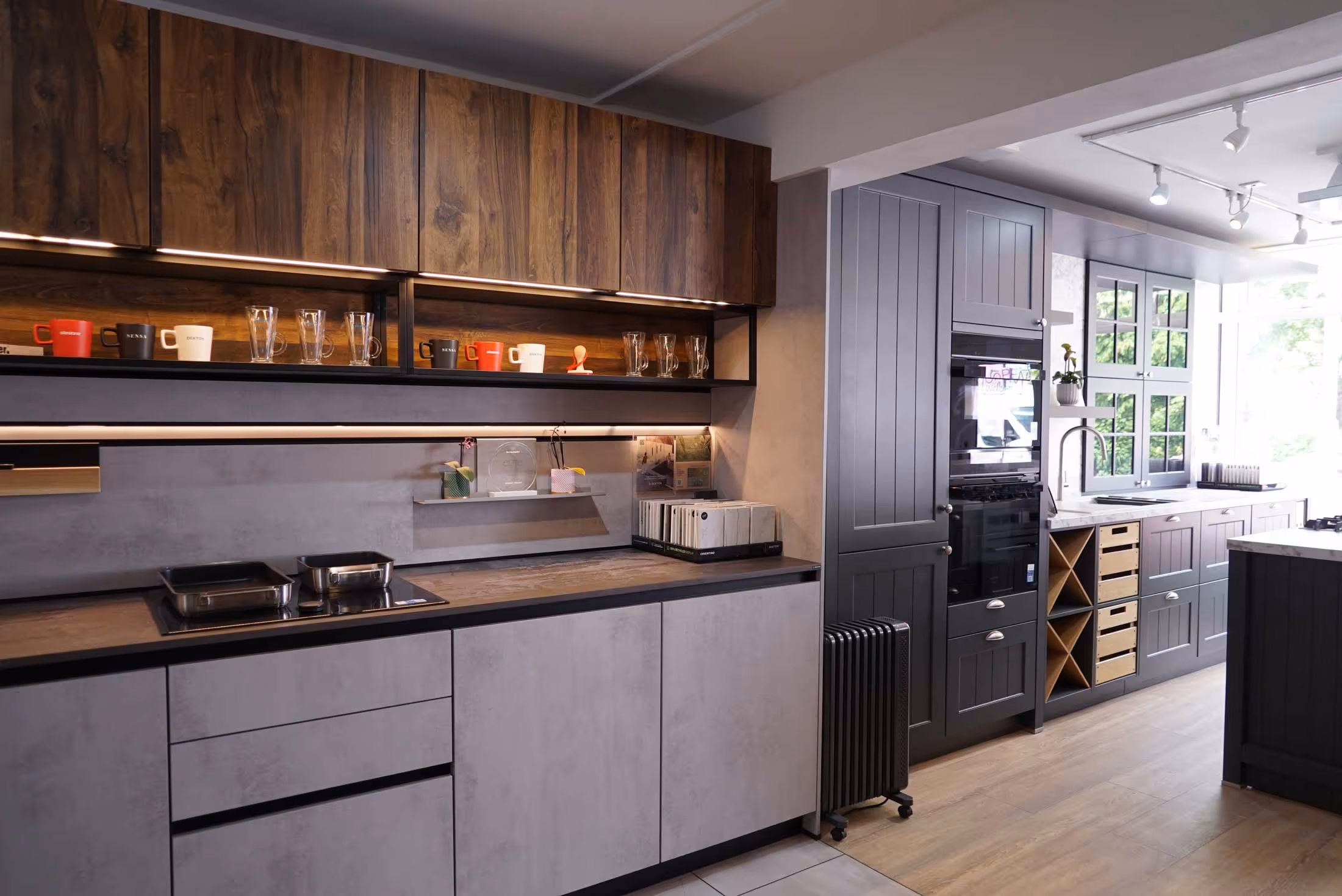 Modern kitchen with light gray cabinets, wooden shelves, and various kitchen appliances on countertops.