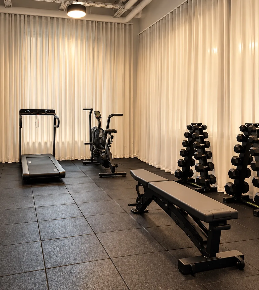 Salle de sport de Habyt Berlin Waterfront avec tapis de course, vélo, banc de musculation et haltères