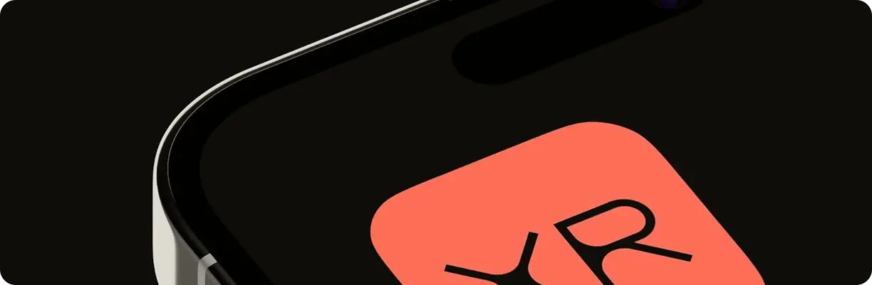 Close-up of a smartphone screen corner displaying an app icon with red background and stylized black letters 'XR'.