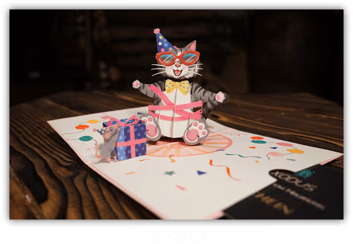 Pop-up Karte für einen Escape Room mit fröhlicher Katze mit Partyhut, roter Sonnenbrille und gelber Fliege neben einer Maus und Geschenk.