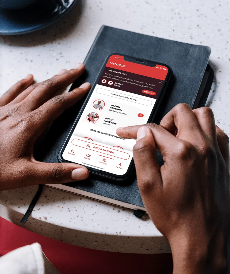 Person holding a smartphone displaying a mentorship app with options to find a mentor and view profiles.