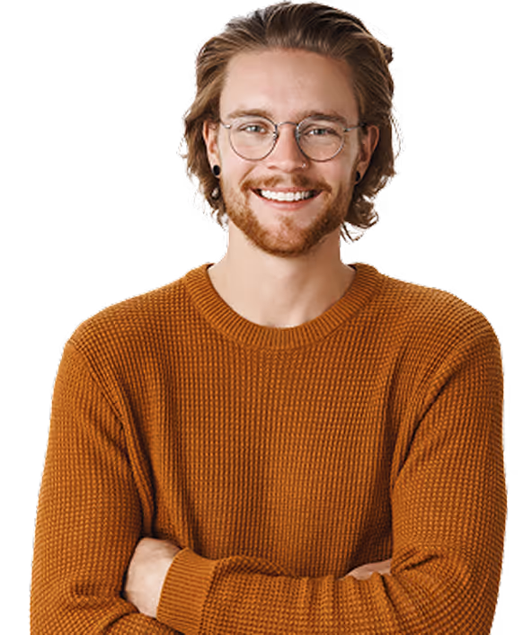 Smiling man with glasses and red beard wearing a brown sweater with arms crossed.