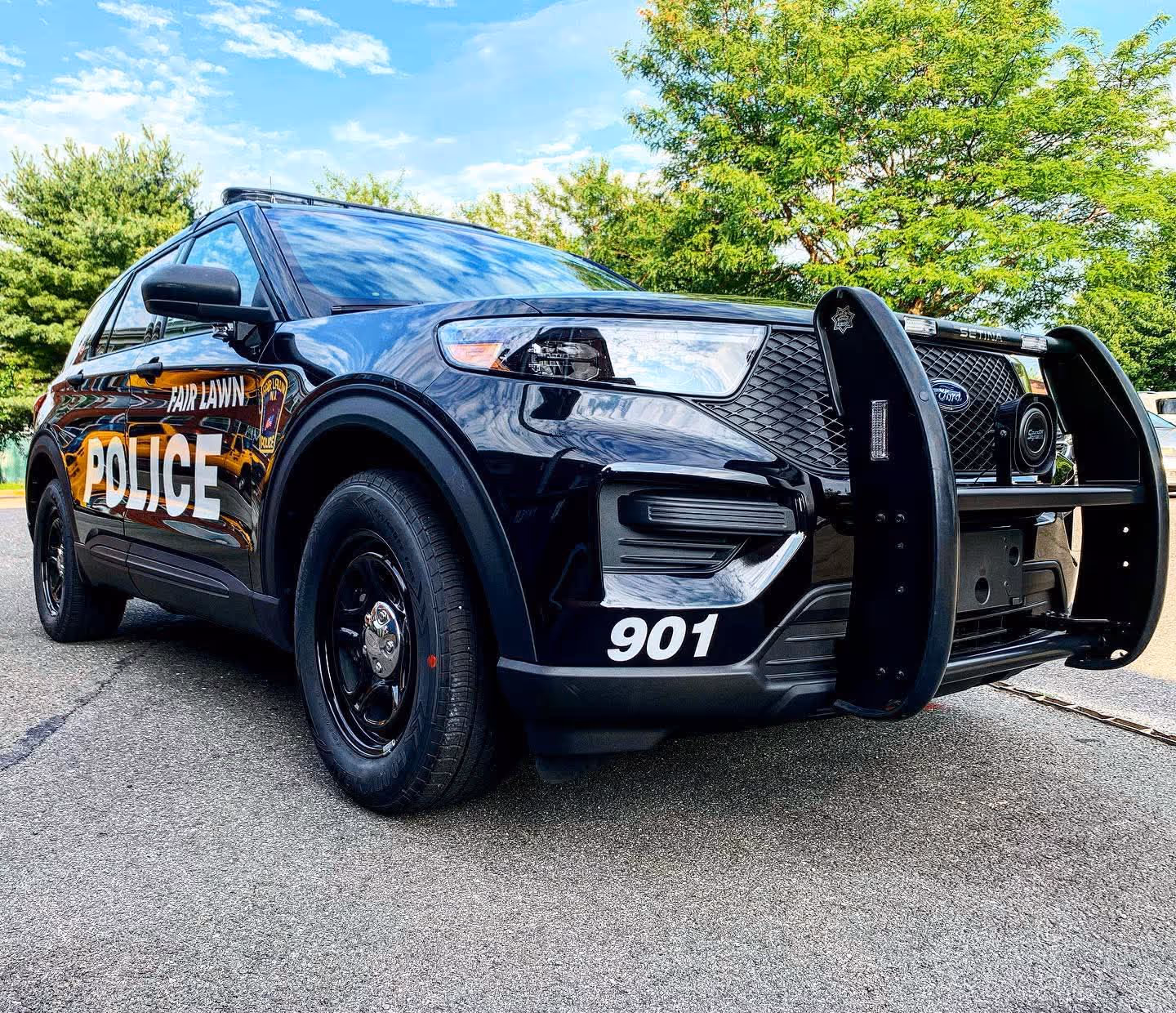 Black Fair Lawn Police SUV with front push bumper parked on pavement with green trees in the background.