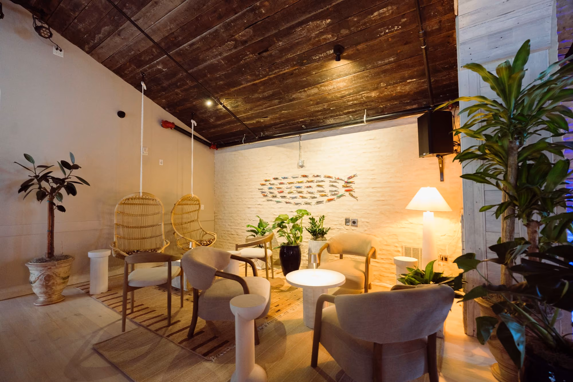 Meraki's Lounge offers intimate swing-chair seating around a lit table beneath a handcrafted fish mosaic.