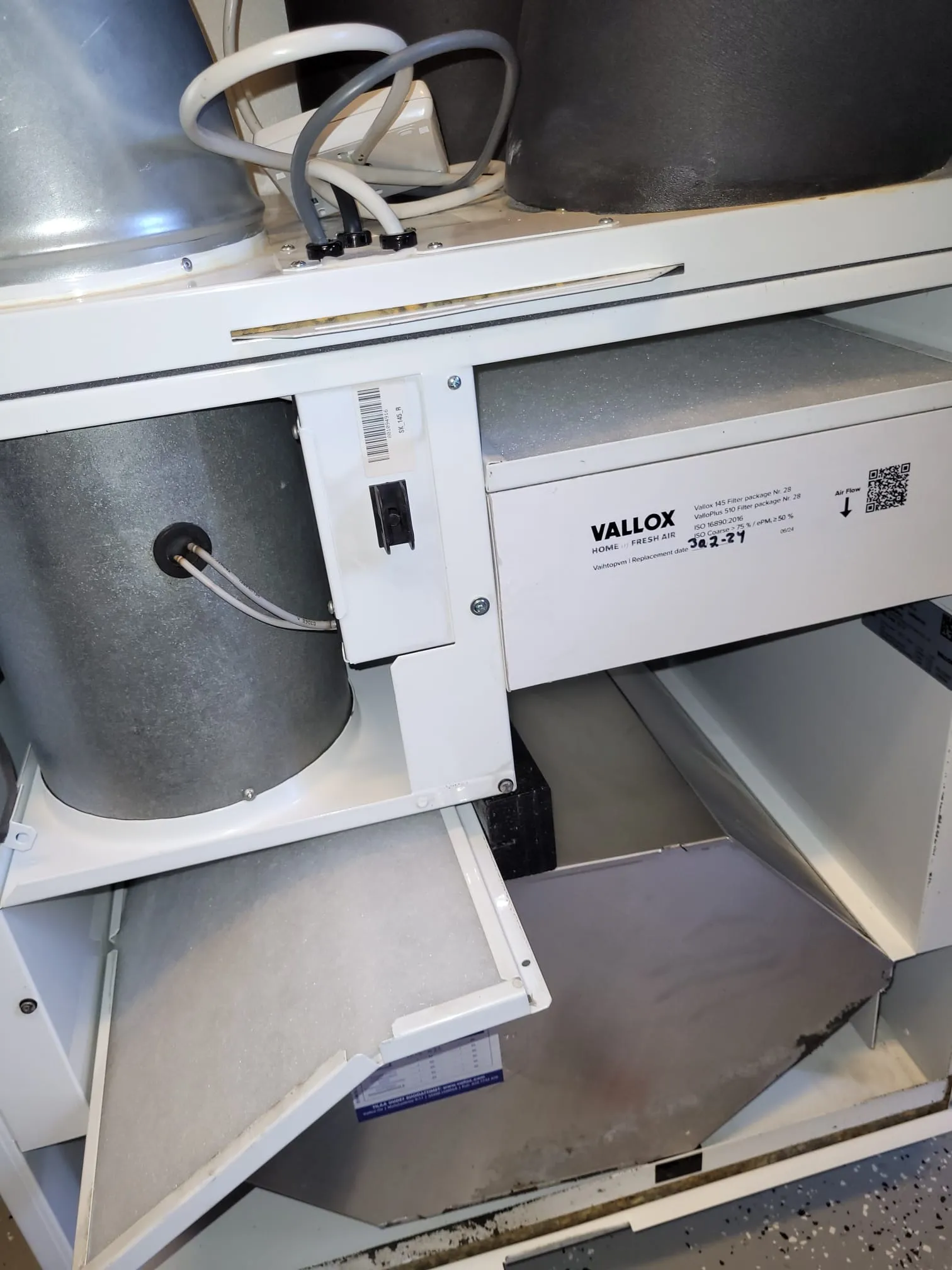 Vallox-ilmanvaihtokoneen suodattimet ja osat, metallipinnat ja valkoinen runko näkyvissä, valaistus kirkas.