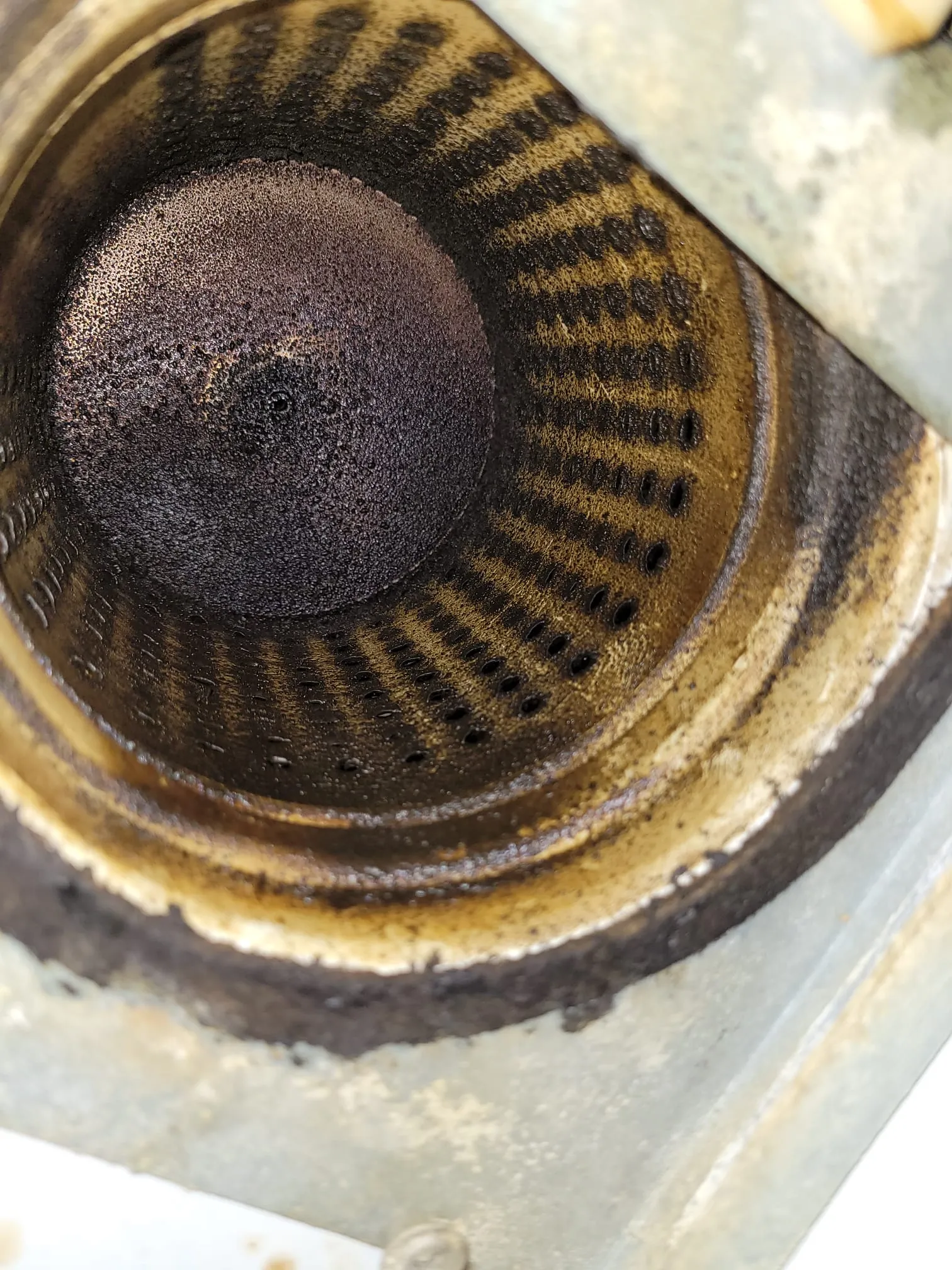 Likaista, sylinterimäistä metalliesinettä, jossa on tumma, huokoinen pää ja rivi reikiä.