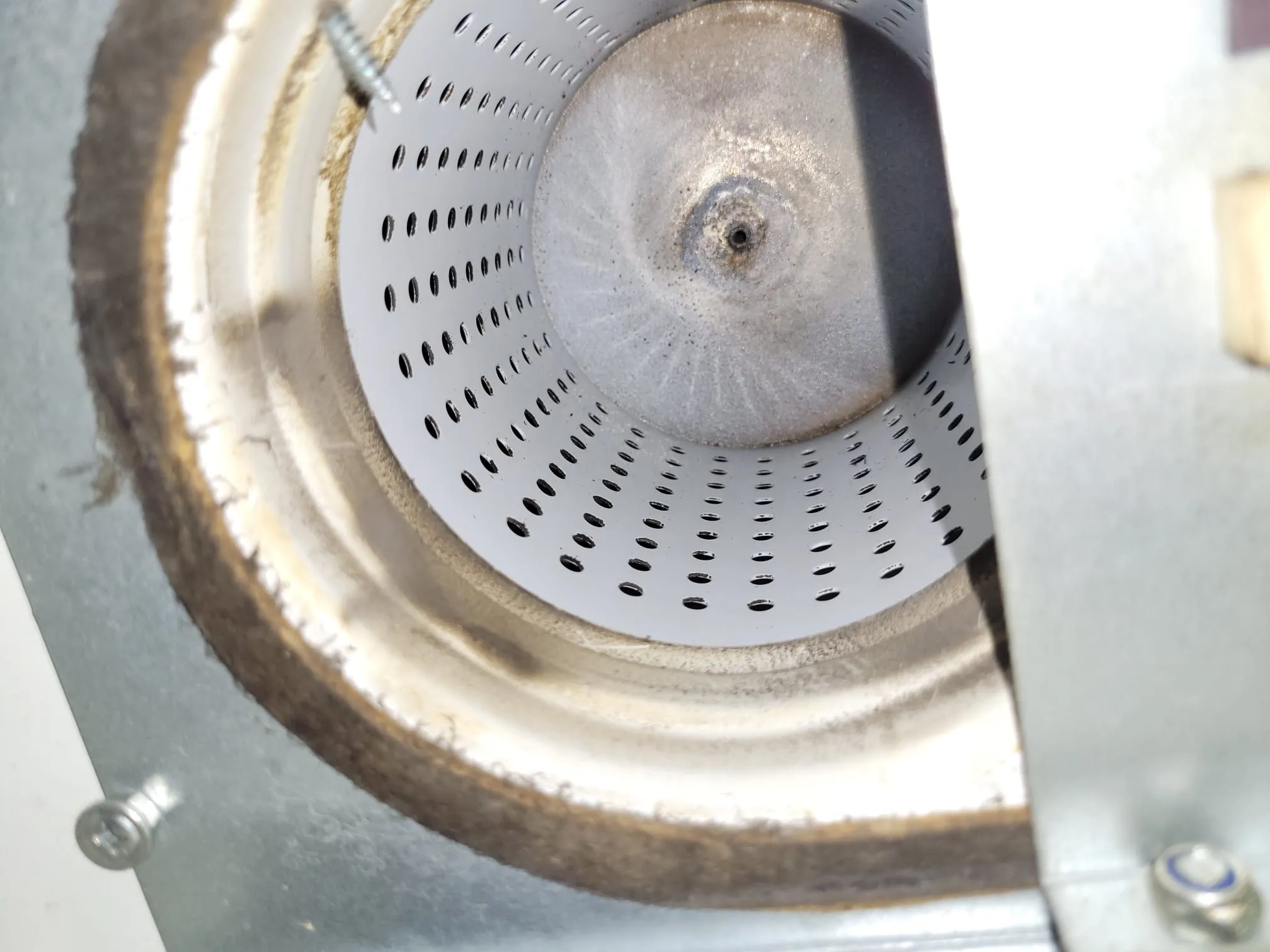 Metallinen, rei'itetty sylinteri, jossa on tumma keskusta ja kiinnitysruuvi, valaistus on kirkas ja tasainen.