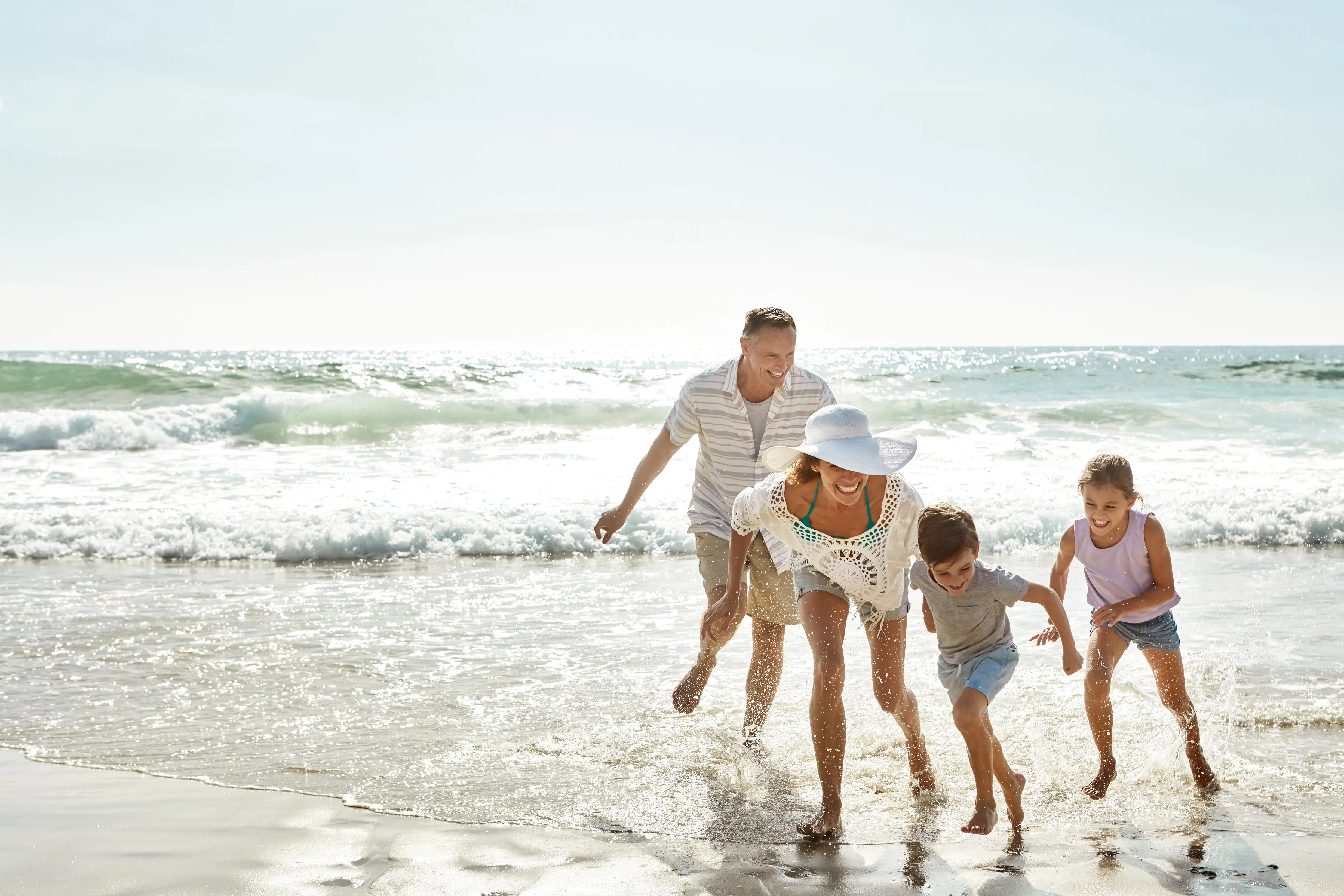 A family playing in the water at the beach.