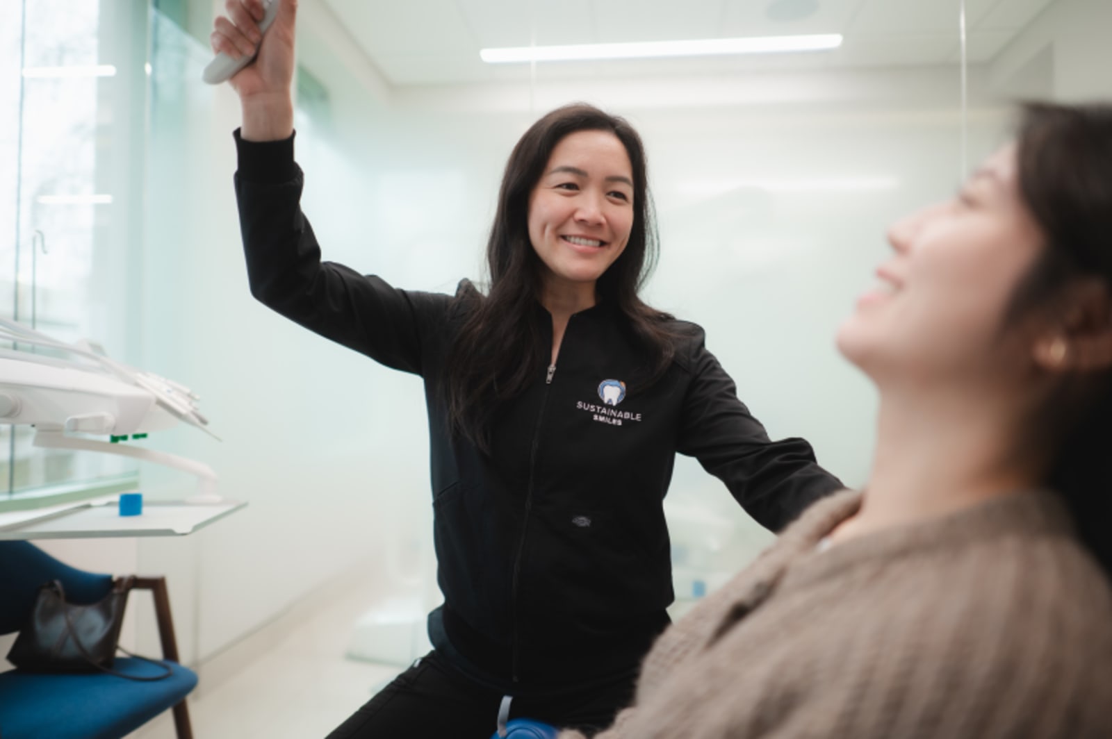 Female dental professional discussing treatment with patient in clinical setting