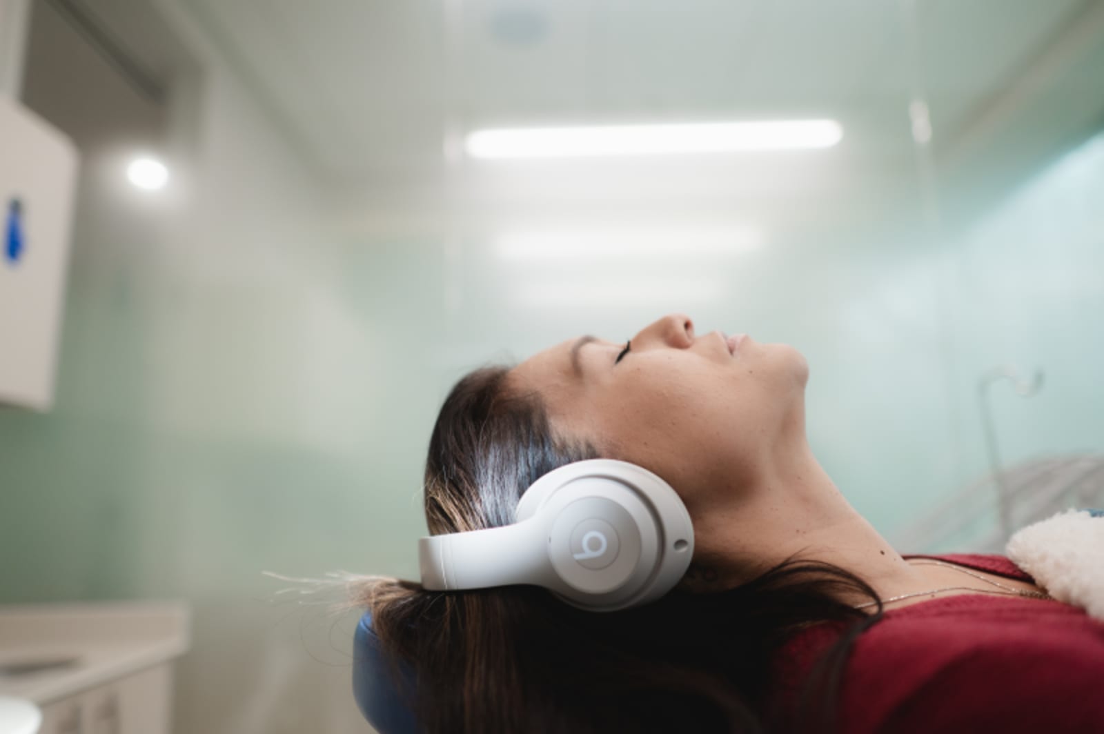 Patient getting comfortable dental care, leaned back and wearing headphones at Sustainable Smiles dental office in Pleasanton, CA