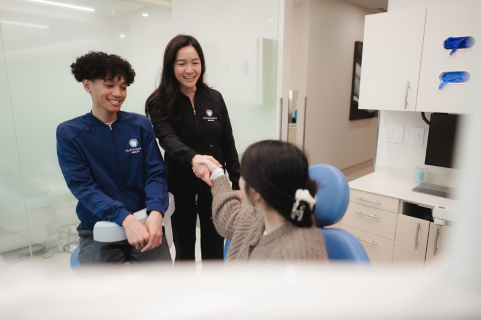 Dentist examining young patient in clinical treatment chair during visit
