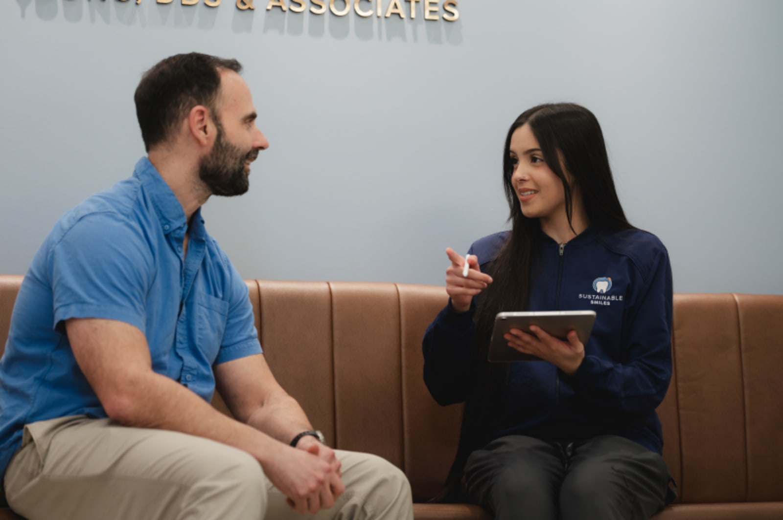 Female dentist consulting with male patient in treatment room discussing implant plan