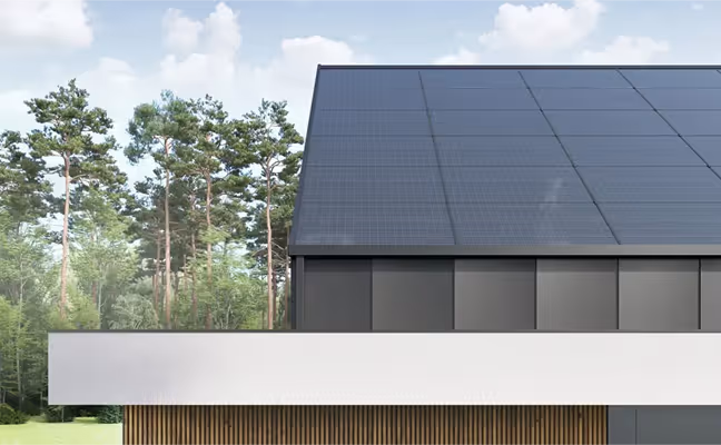 Krov moderne kuće prekriven solarnim panelima pod vedrim nebom.