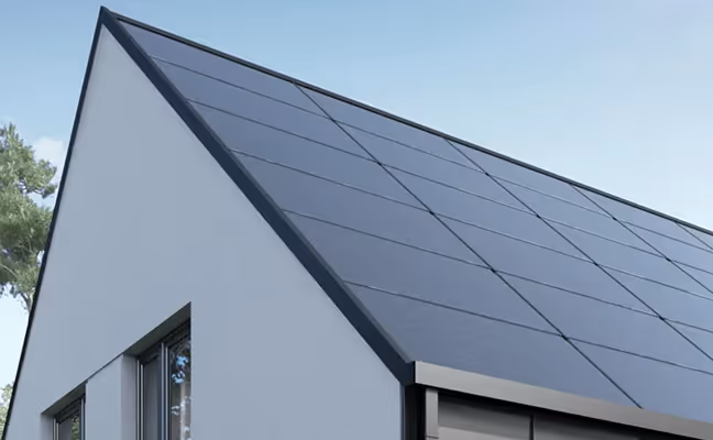 Krov moderne kuće prekriven solarnim panelima pod vedrim nebom.