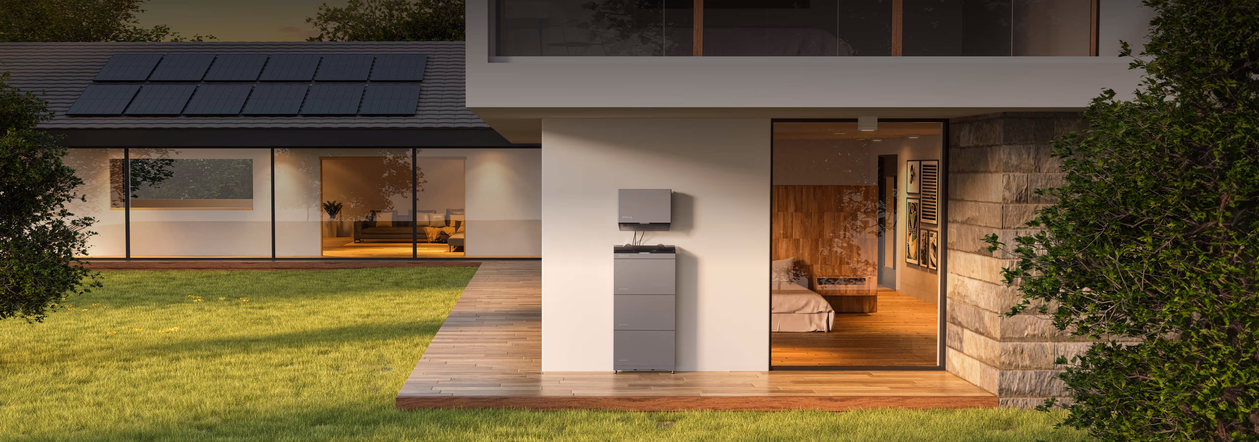 Modern house with solar panels on roof and a battery storage system installed outside on a wooden deck.