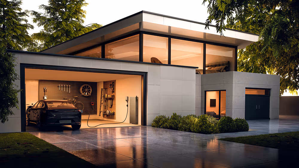 Modern house with large windows and an electric car charging inside an open garage at dusk.