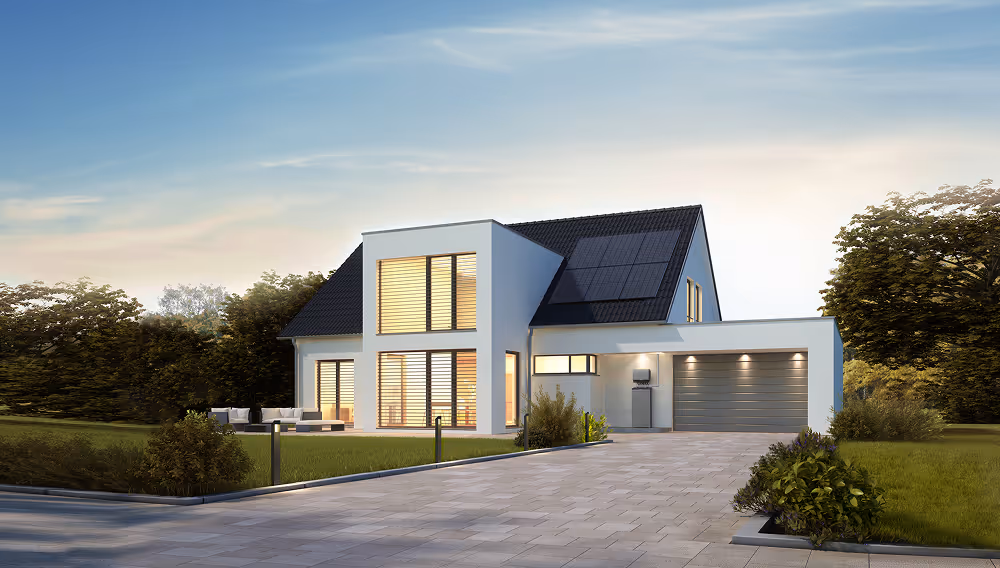 Modern two-story white house with solar panels, large windows, garage, and driveway at sunset.