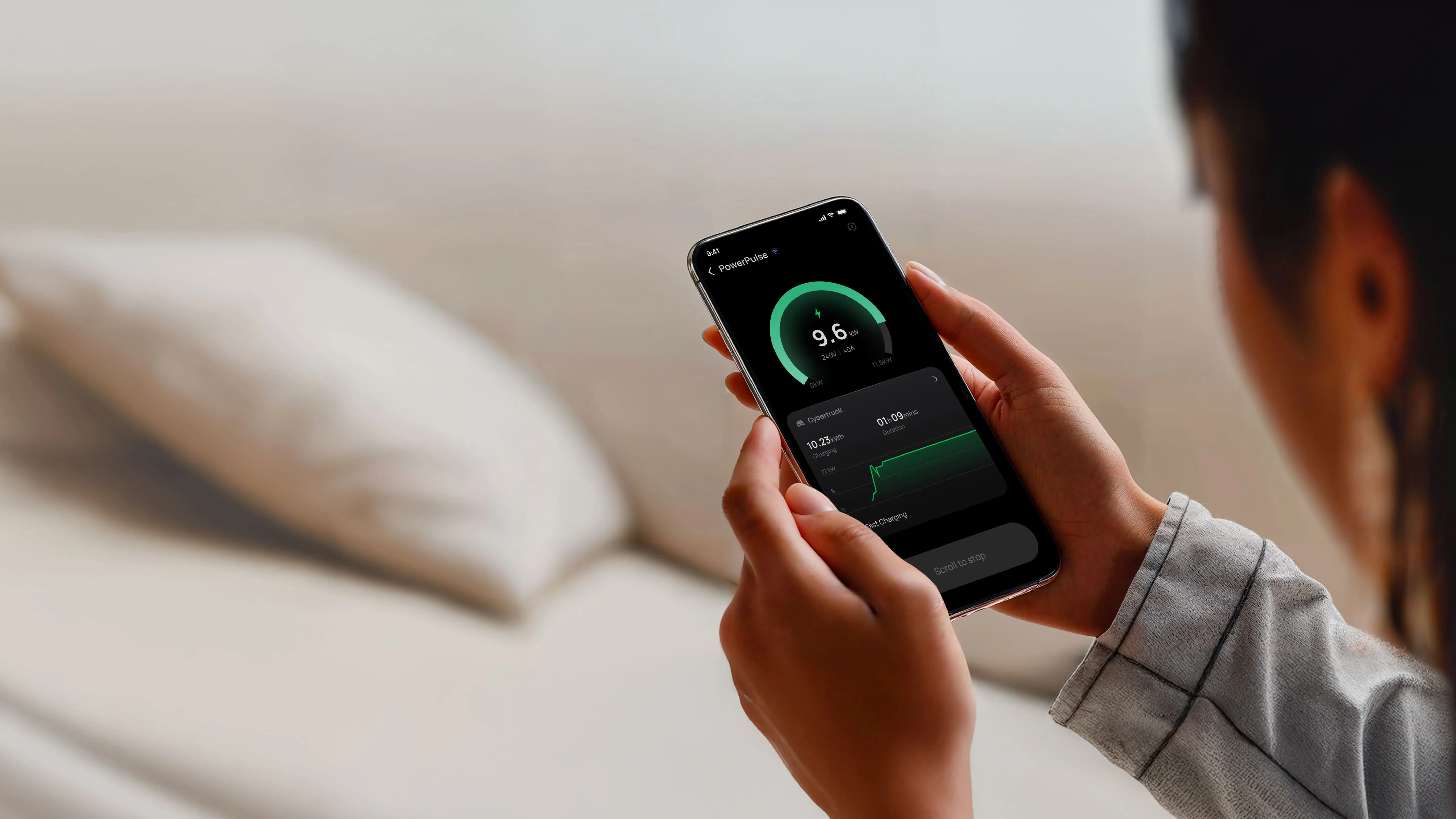 Person holding phone with app showing 9.6 kW power charging data and charging duration.