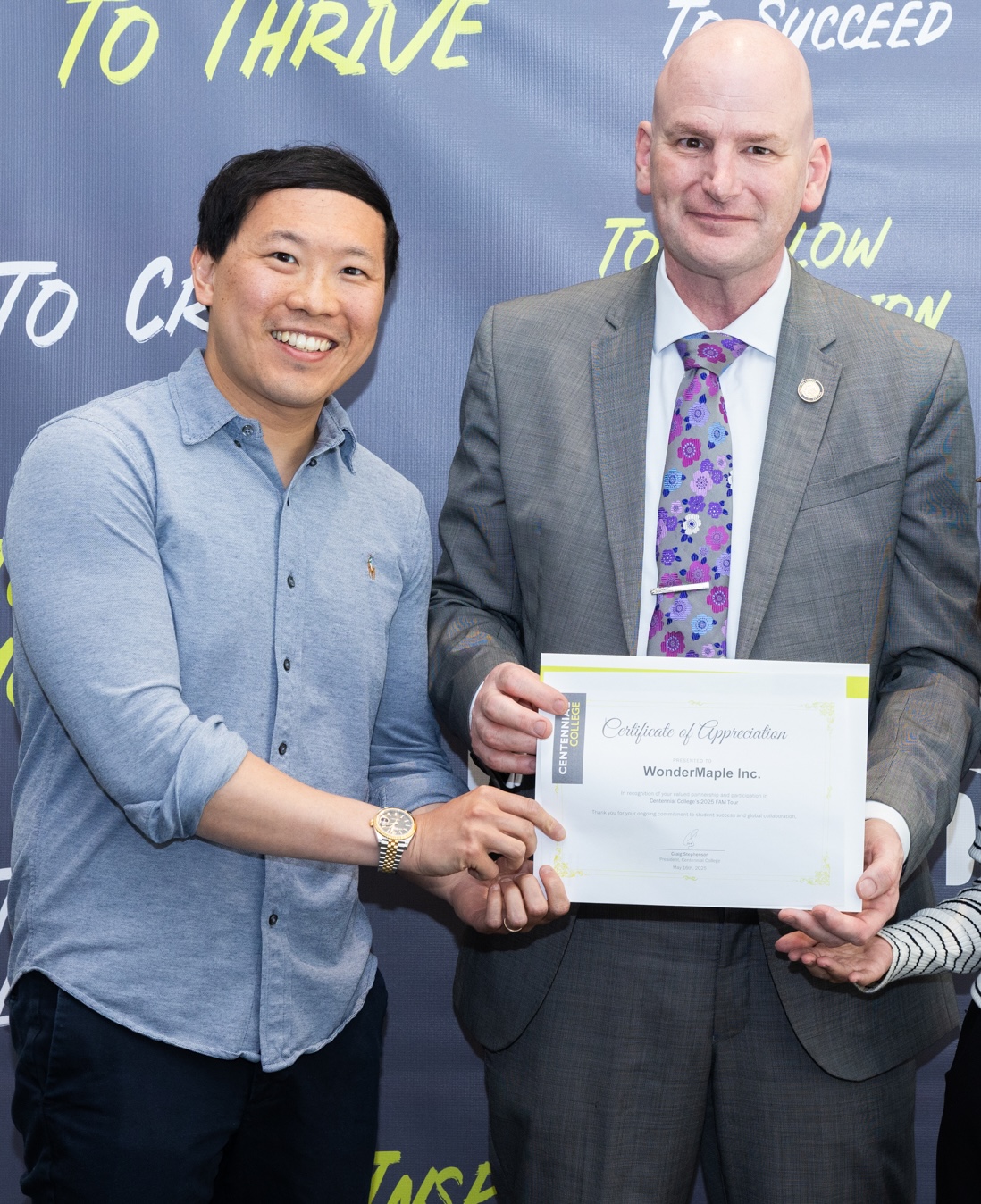 Two men smiling and holding a Certificate of Appreciation awarded to WonderMaple Inc. from Centennial College. education marketing agency for K-12 and HigherEd WonderMaple Strategy