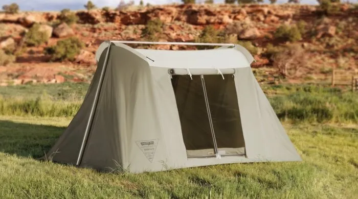 A Springbar canvas tent pitched on grass in red rock country