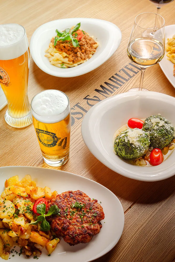 Gedeckter Tisch mit deftigen Speisen und Getränken