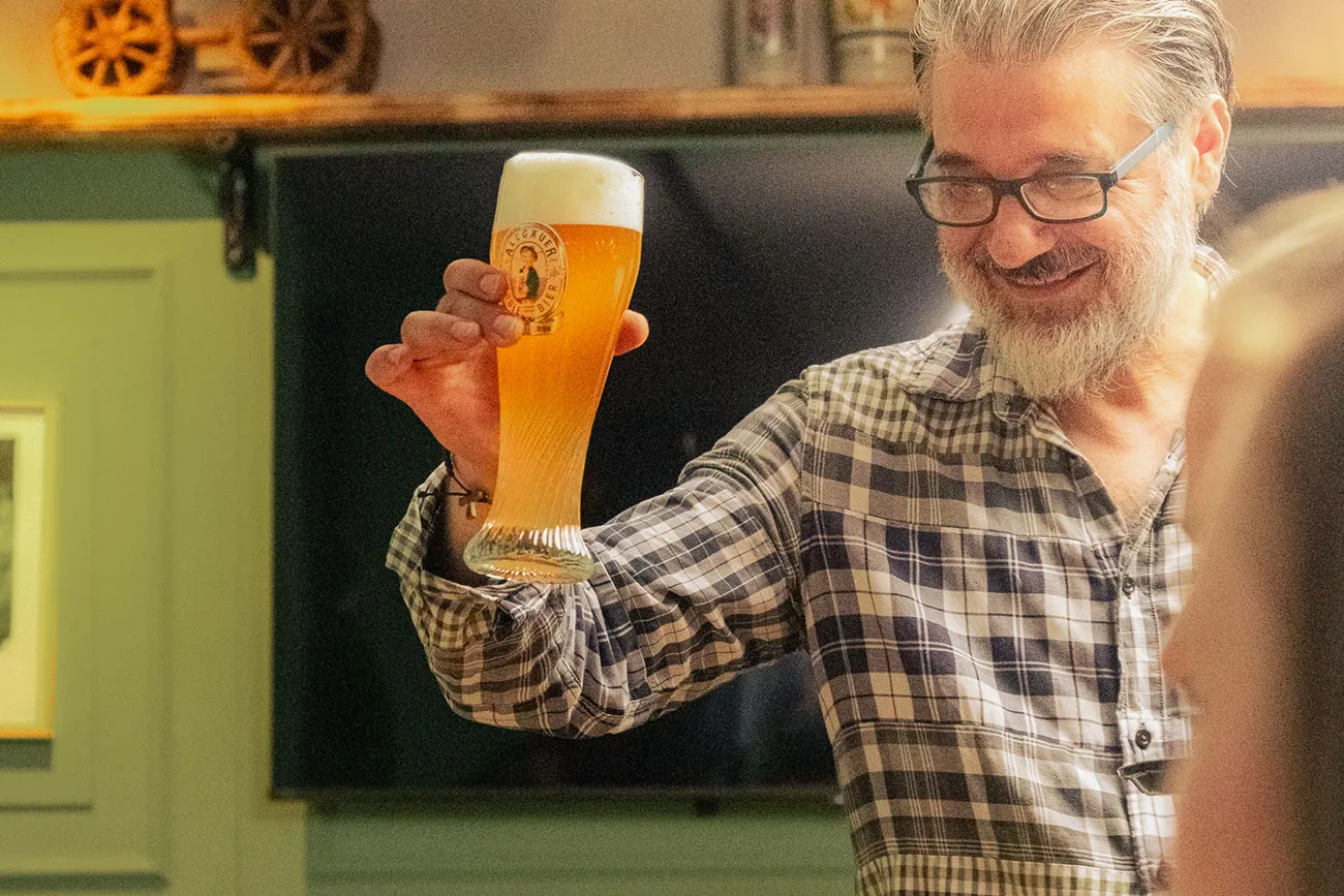Weihnachtsfeier in Mainz – Mann hält Bier in der Hand im Restaurant Prost & Mahlzeit