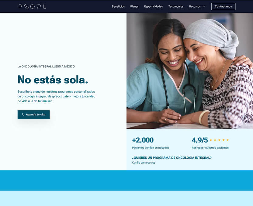 Smiling female healthcare professional comforting a woman wearing a headscarf, symbolizing support in oncology care.