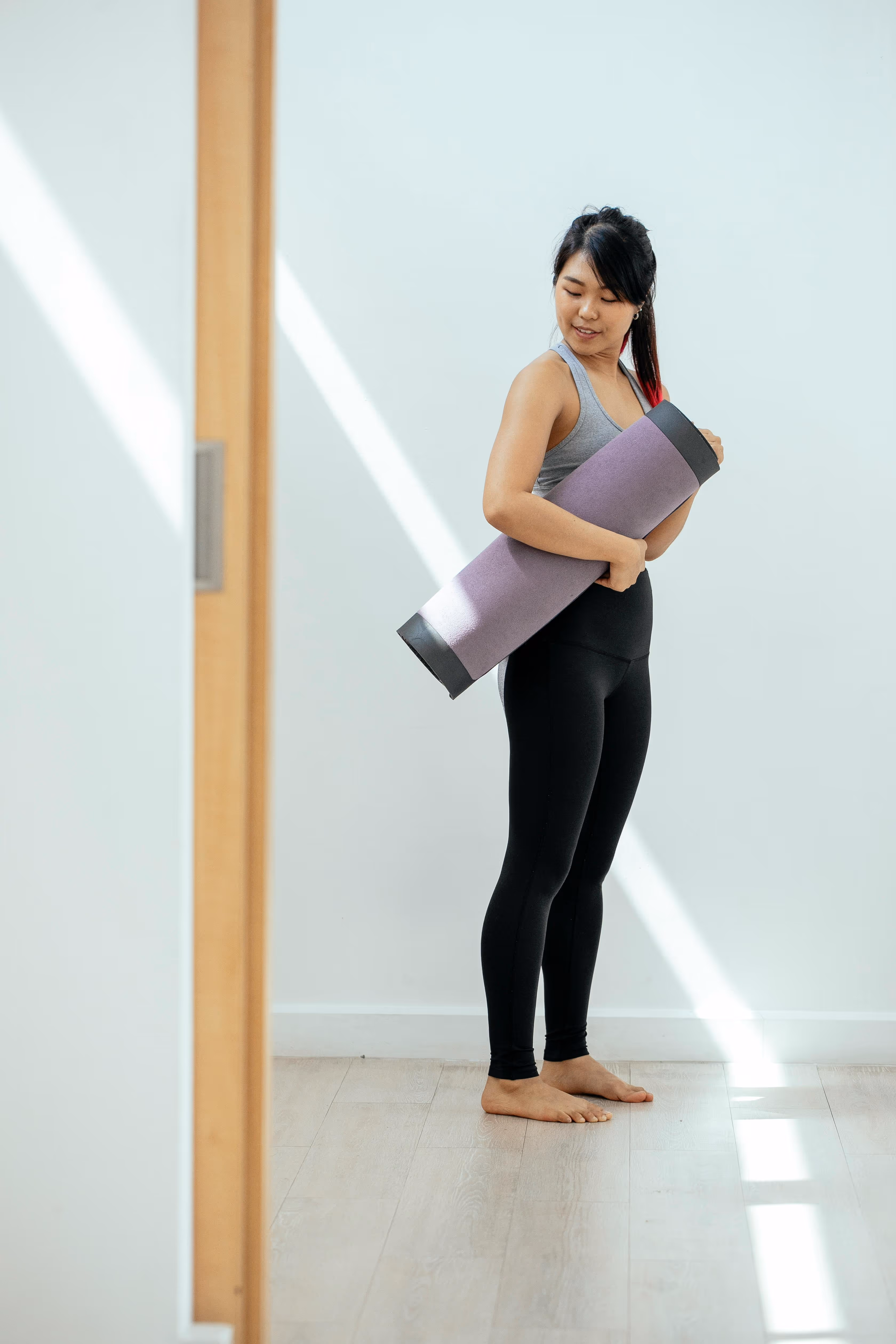 Woman holding yoga mat