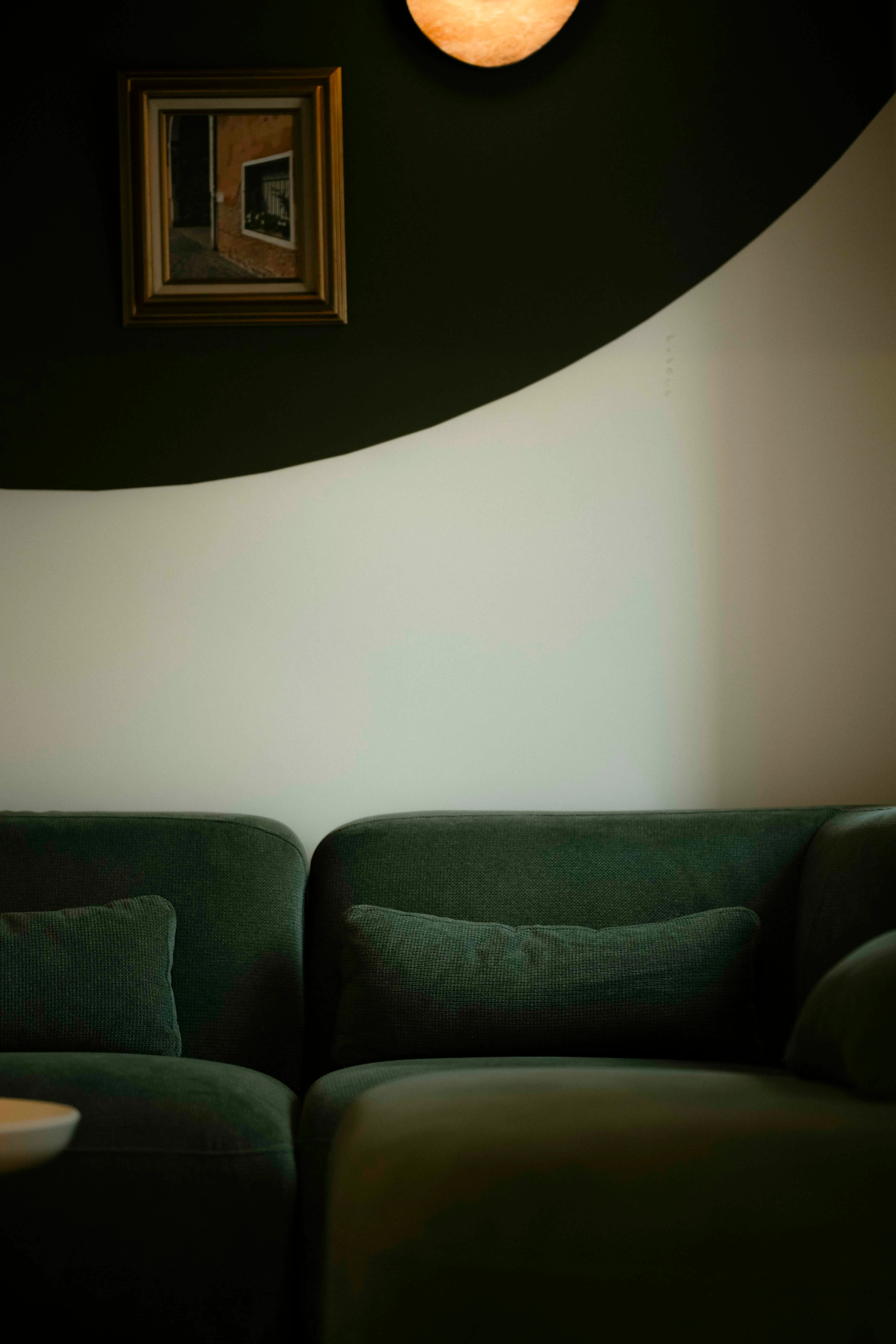 Green velvet sofa and curved wall detail in the Connections event space at La Maison Ralia Montreal