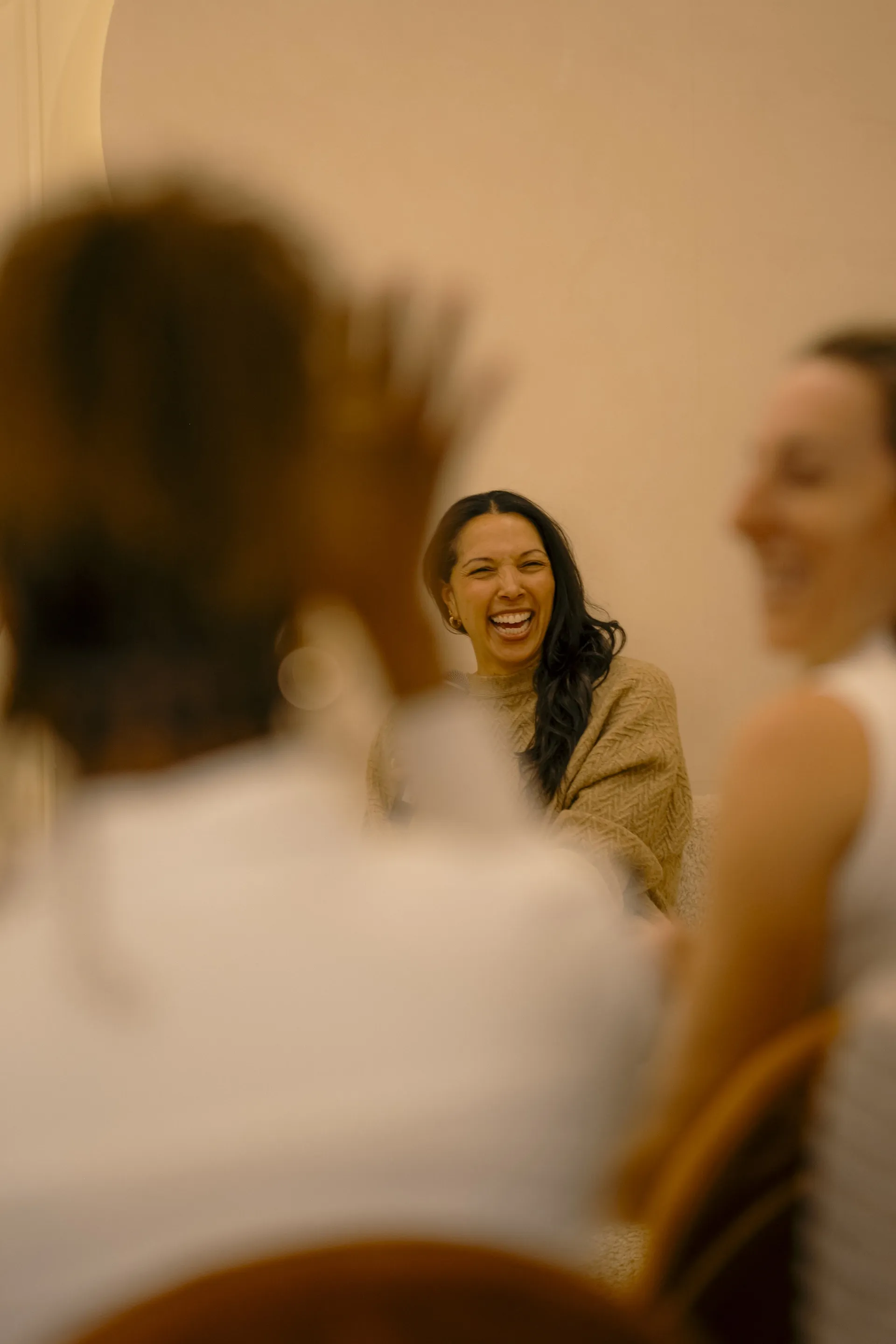 Woman laughing with other guests during a gathering at a Ralia event space