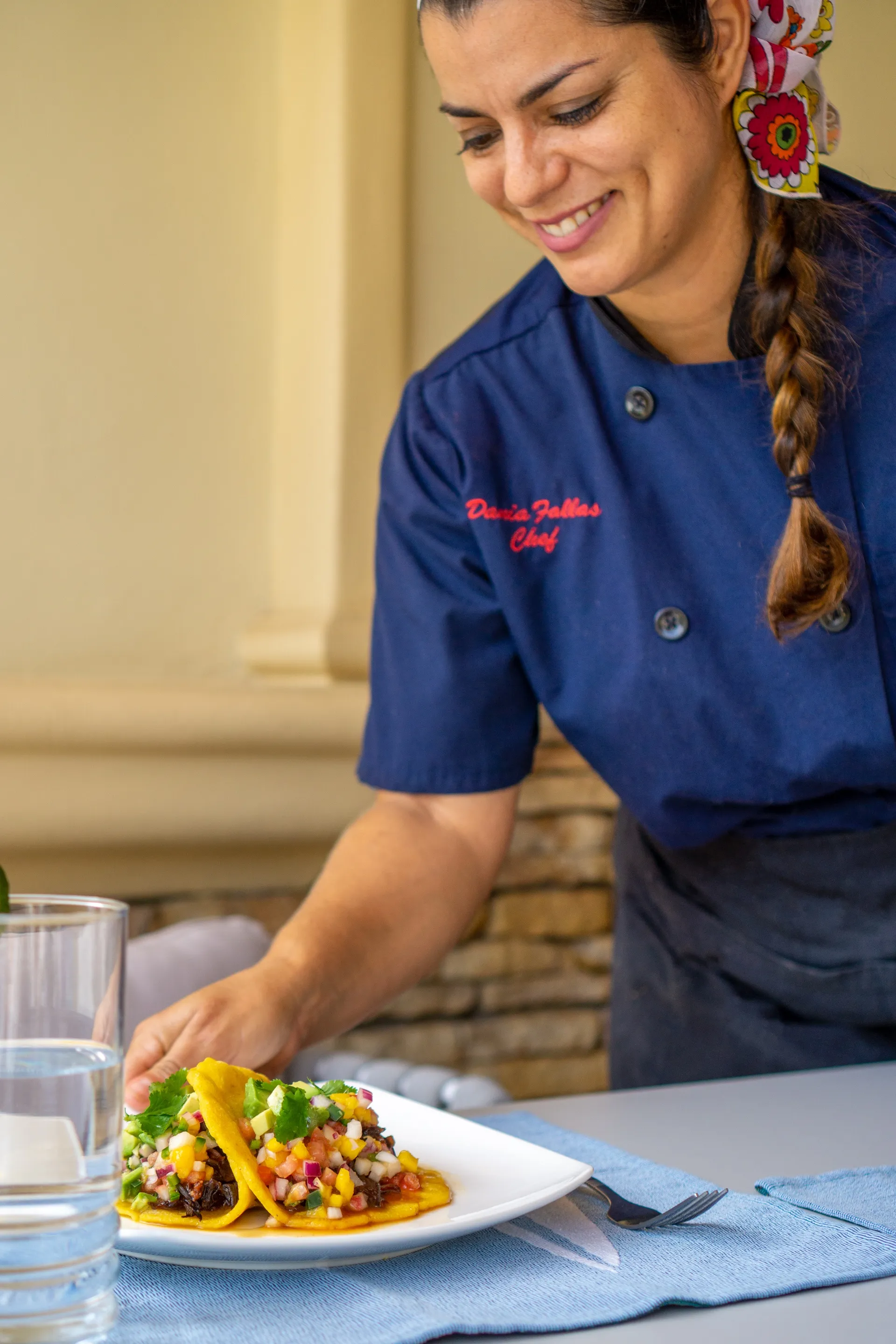 Chef in a navy jacket plating fresh tostadas with corn salsa at the Costa Rica retreat