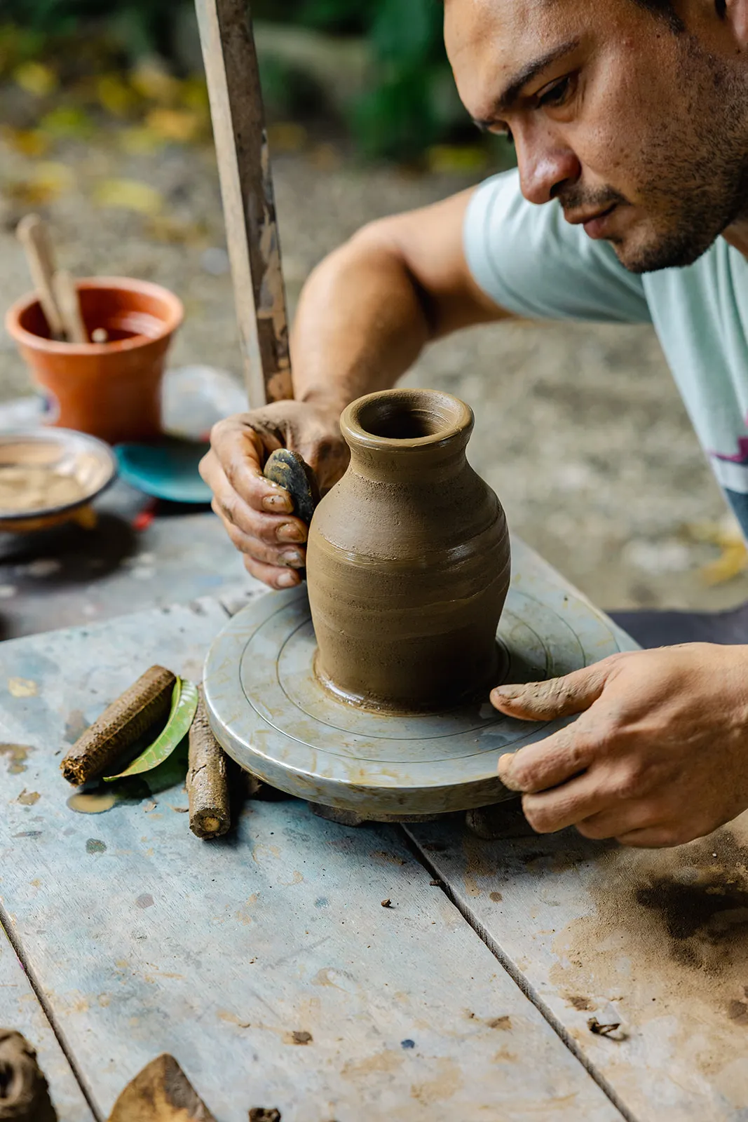 Local artisan shaping a clay pot on a potter's wheel during a Costa Rica retreat workshop