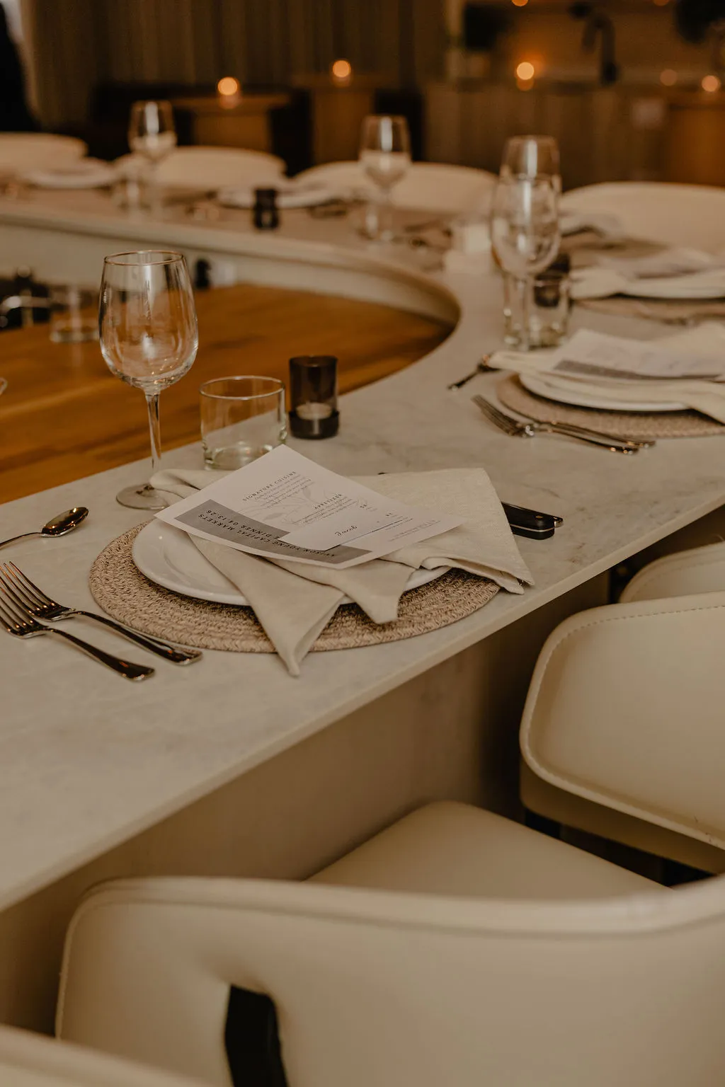 Curved chef's table set with menus, wine glasses and linen napkins for a private dinner at La Maison Ralia