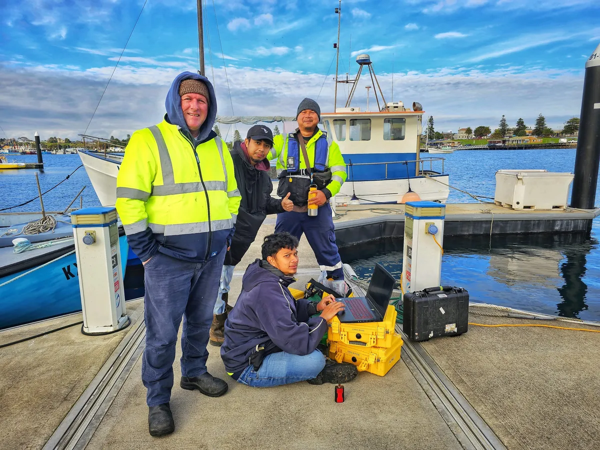 Field team setting up GNSS base and rover equipment on the wharf