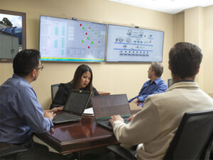 Technical professionals meeting in conference room to plan SCADA graphics approach for client