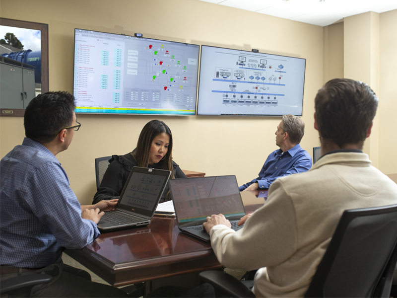 Technical professionals meeting in conference room to plan SCADA graphics approach for client