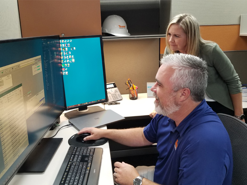EMASS programmer and project manager review a client's SCADA system.