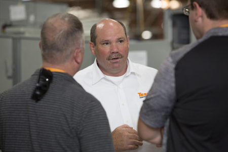 TESCO executive consulting with clients in manufacturing facility