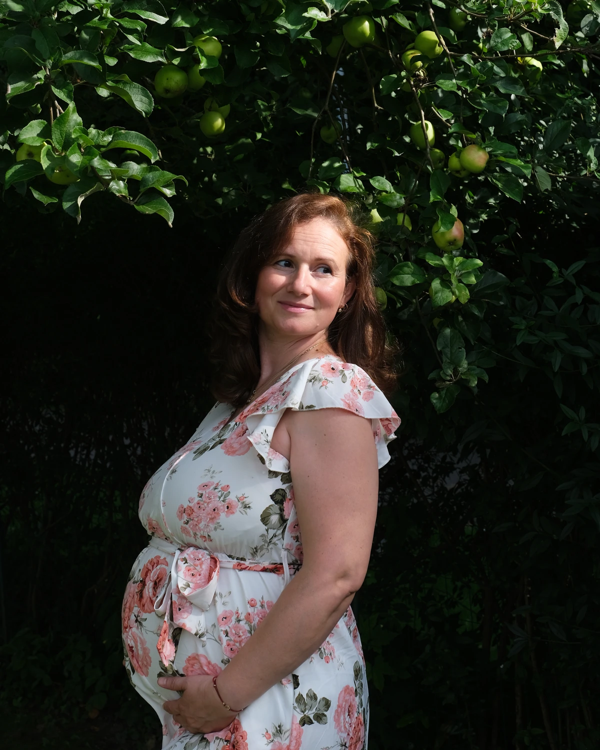Diana Z. Petrova during pregnancy beneath an apple tree.
