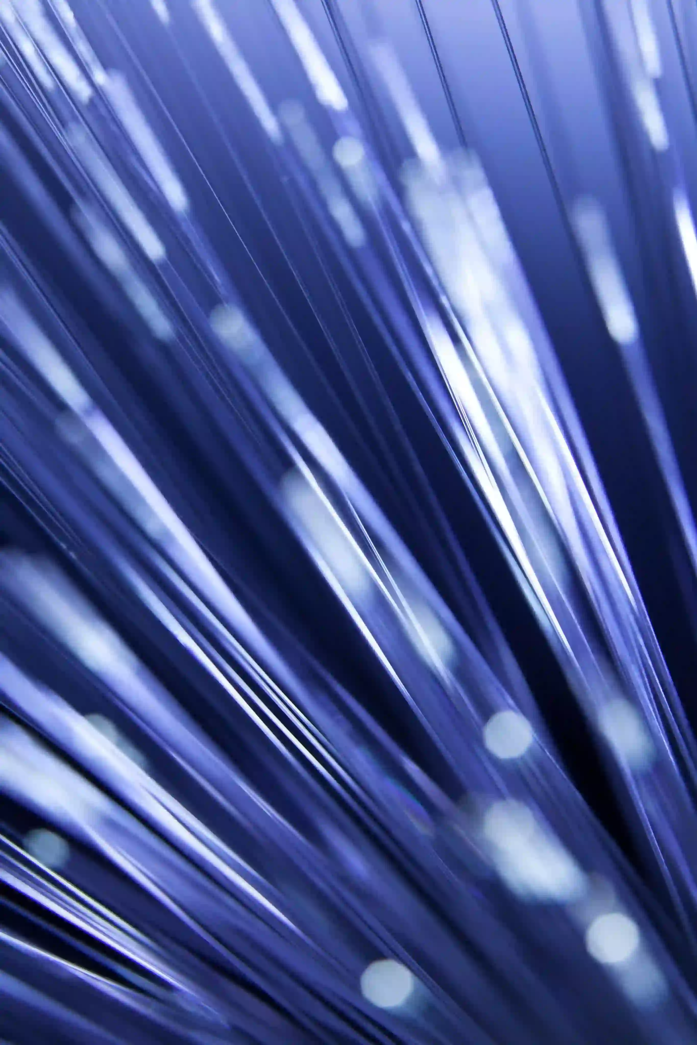 Close-up of blue fiber optic strands emitting light against a dark background.