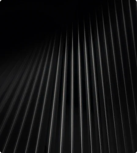 Close-up of vertical black metallic slats with thin white light reflections.