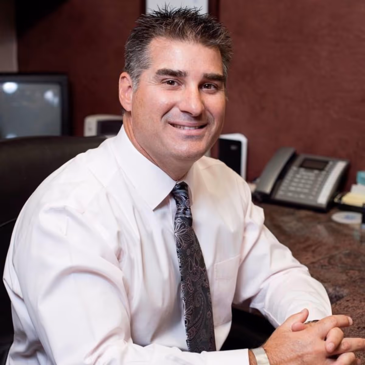Dr John Garza sitting at his desk