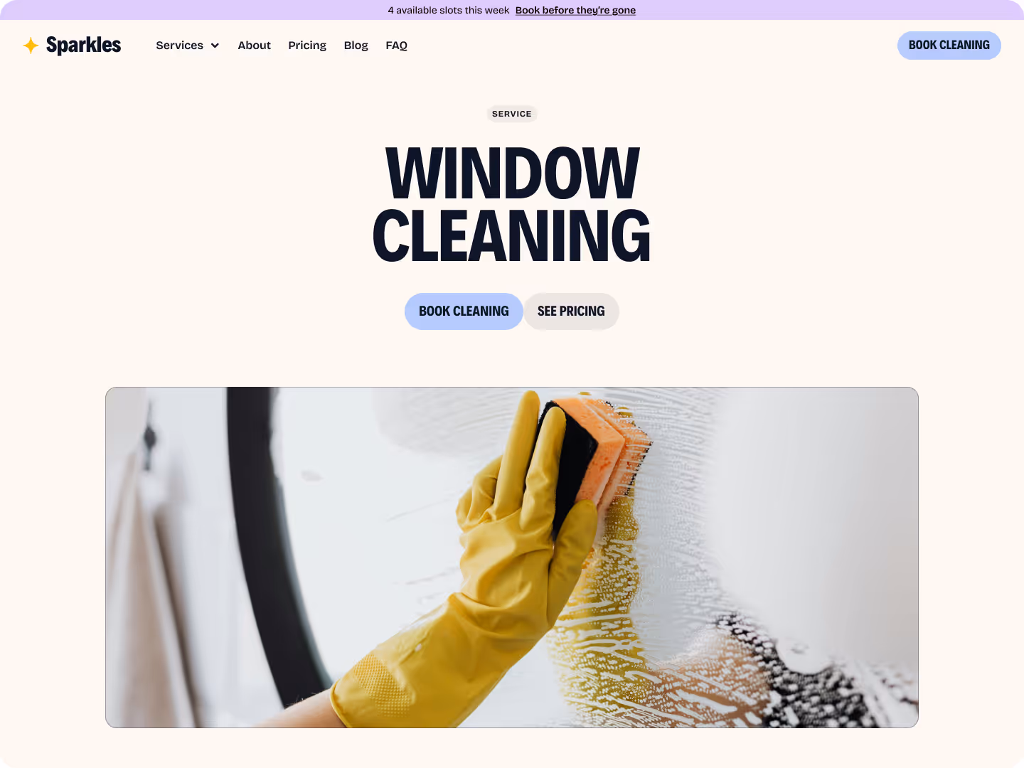 Person wearing yellow gloves cleaning a window with a sponge covered in soap suds.