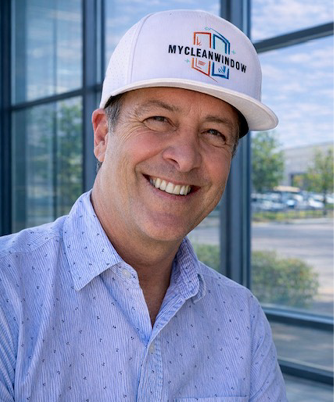 MyCleanWindow owner smiling in branded white cap
