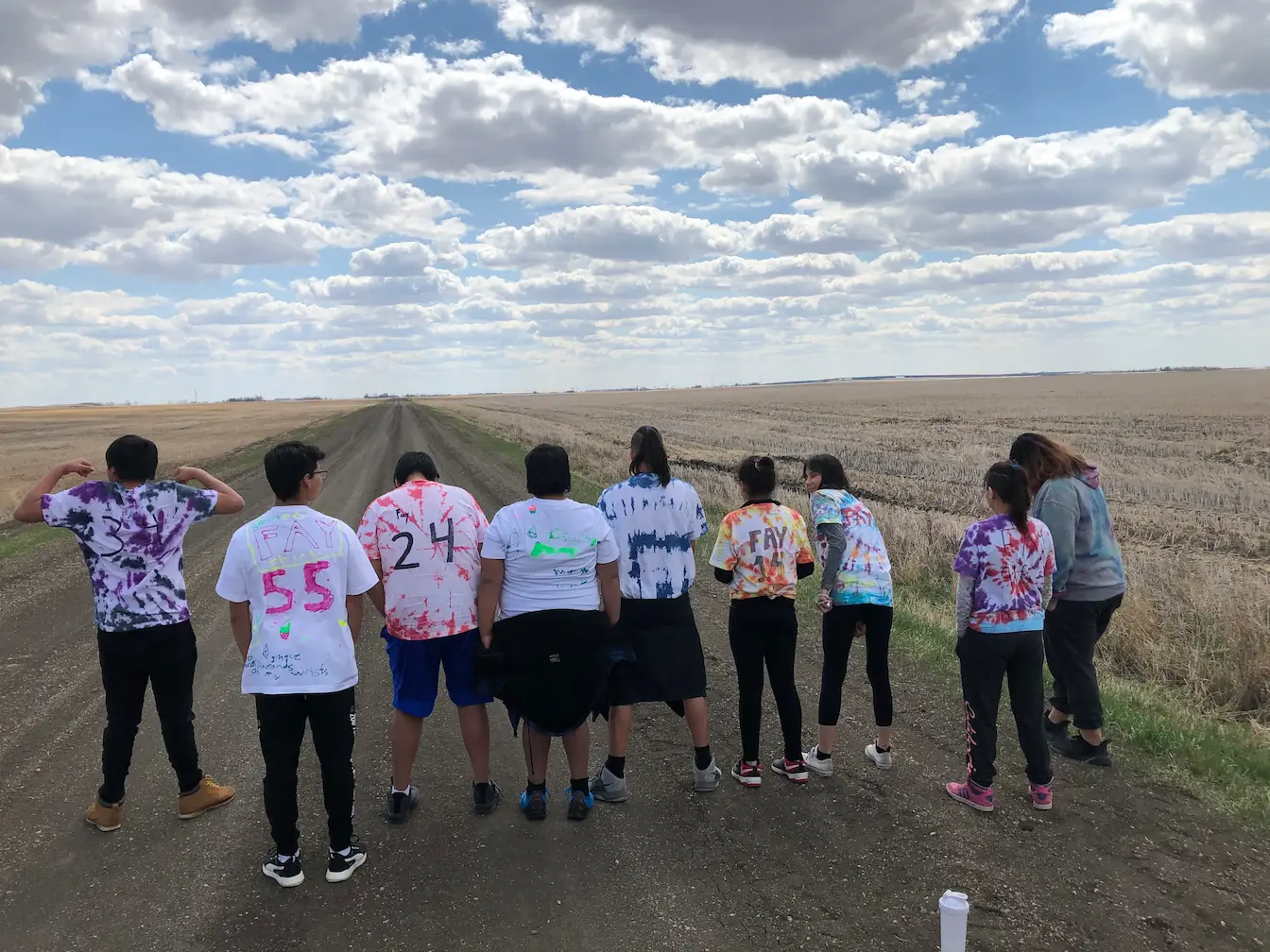 Ranch Ehrlo Society youth standing on a rural road in Saskatchewan