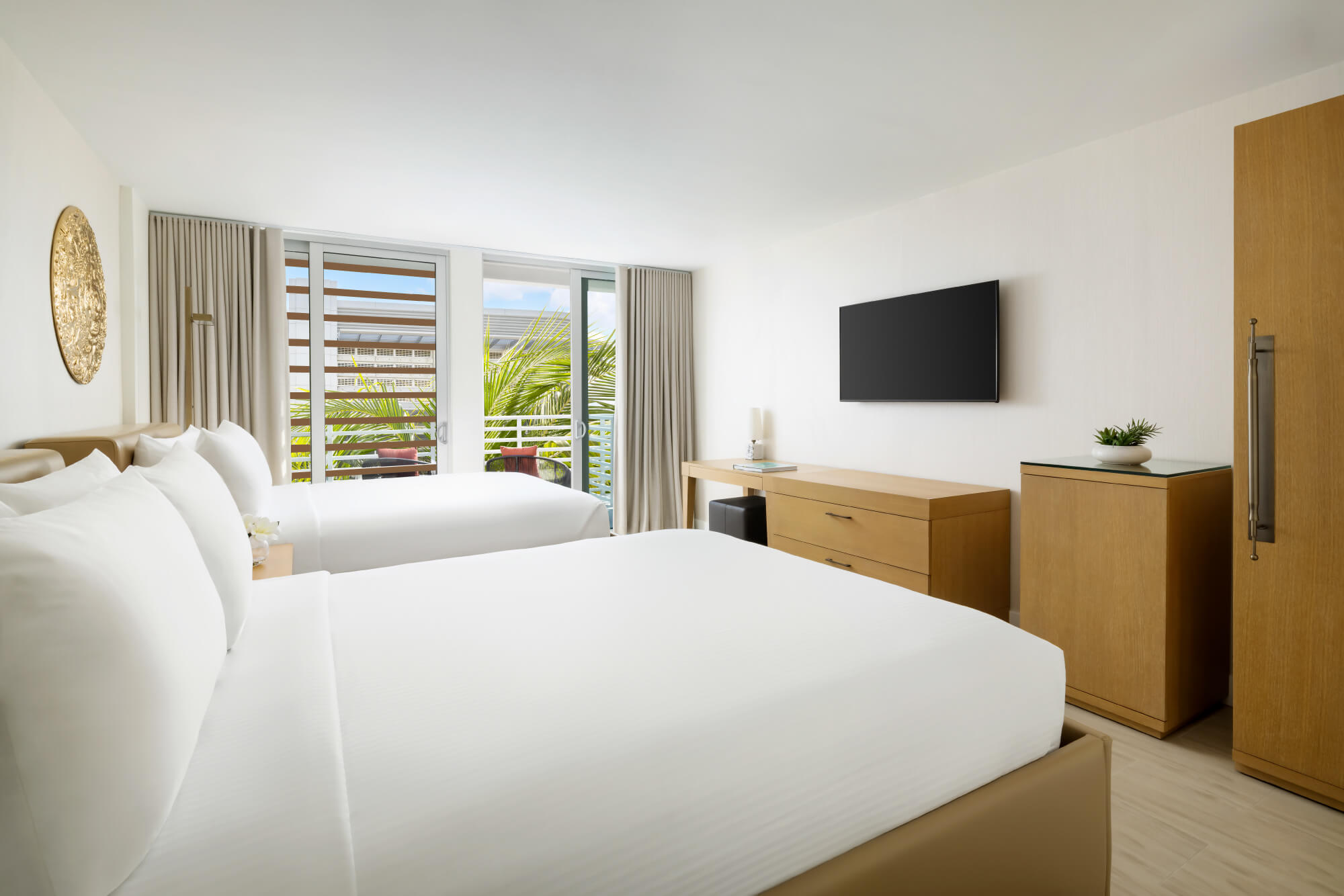 two neatly made beds of hotel room a collins court with tv and view