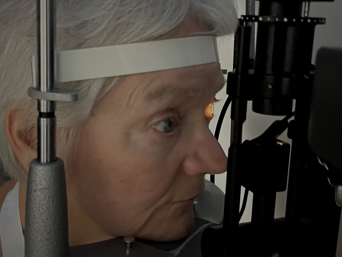 A patient at the slit lamp chin rest and forehead support during an SVS demonstration.