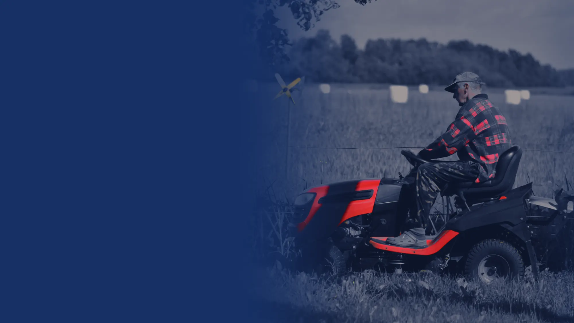 Operator on a red riding mower beside a farm field